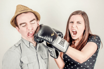 woman hitting a man with boxing glove