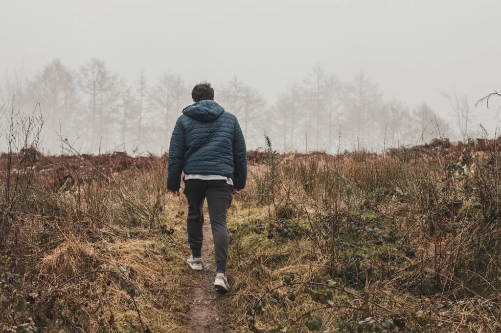 man walking in brown field